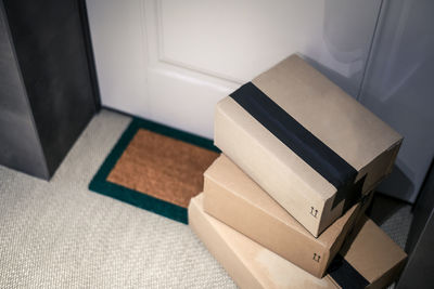 Stack of brown cardboard boxes in front of the house door. order on delivery, box on the doormat. 