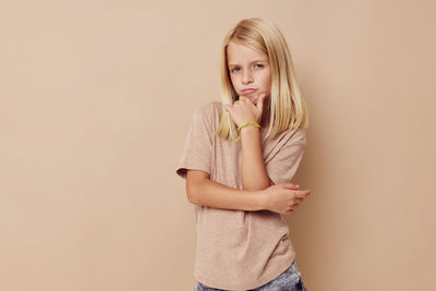 Young woman standing against wall