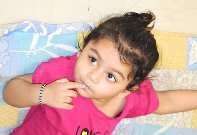 Portrait of cute girl lying on bed at home