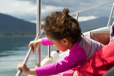 Cute girl sitting in boat at lake