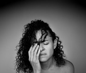 Close-up of depressed woman against colored background