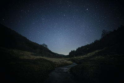 Scenic view of mountains against sky at night