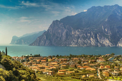 Scenic view of sea by buildings against mountain