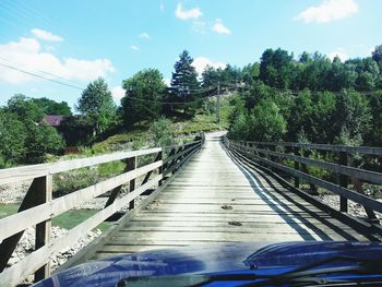 Empty footbridge with trees in background