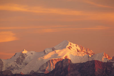 Scenic view of snowcapped mountains against sky during sunset