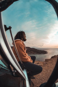 Rear view of man sitting on beach