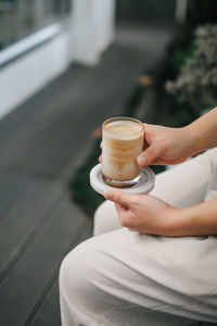 Midsection of man holding coffee cup