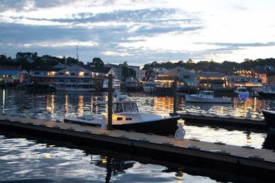 Boats moored at harbor against sky