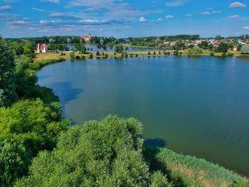 Scenic view of lake by buildings against sky