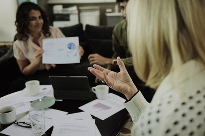 Group of business people analyzing charts during meeting in lobby