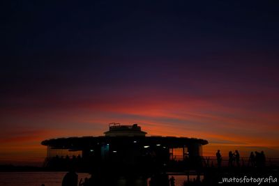 Silhouette of building against cloudy sky during sunset