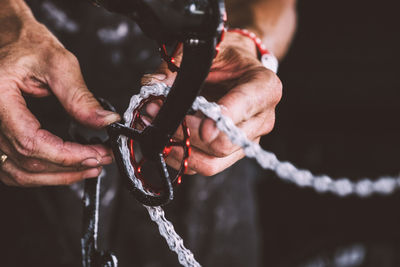 Close-up of mechanic repairing bicycle chain at workshop