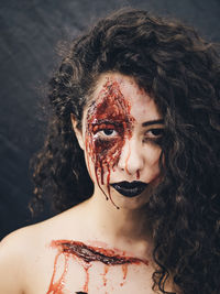 Close-up portrait of young woman with spooky face paint