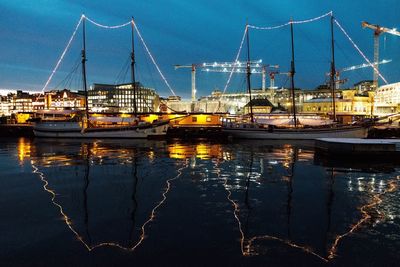 Sailboats moored at harbor against sky