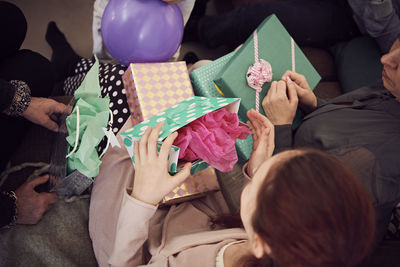 High angle view of girl receiving birthday presents from family at home