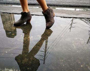 Low section of woman walking in puddle