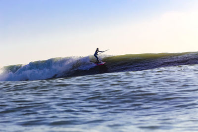 Man surfing in sea against clear sky