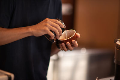 Midsection of man holding coffee cup