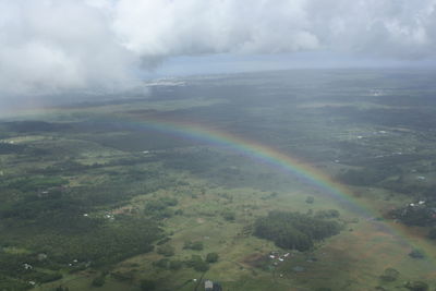 Scenic view of rainbow over land against sky