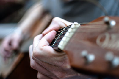 Close-up of male hands playing guitar
