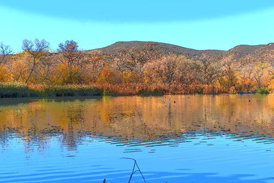 Scenic view of lake against clear blue sky