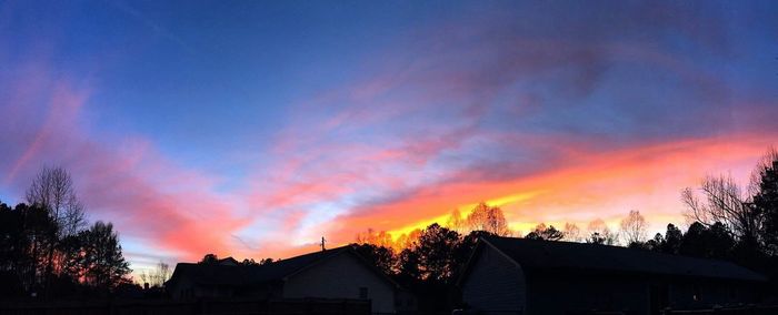 Low angle view of houses against sky at sunset