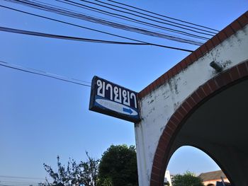 Low angle view of text on bridge against clear blue sky