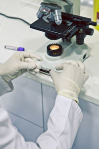 Midsection of scientist examining chemical at laboratory