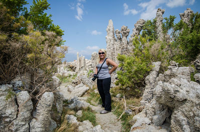 Man standing on rock against sky