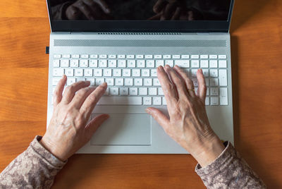 Low section of person using laptop on table