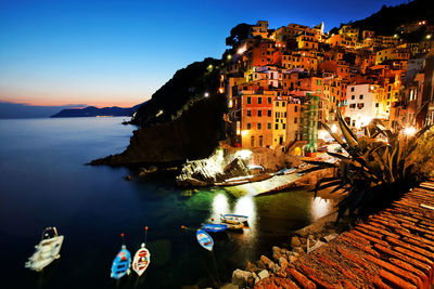 Buildings by sea at cinque terre during dusk