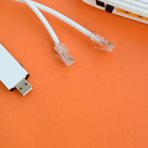 High angle view of router with cables on orange background