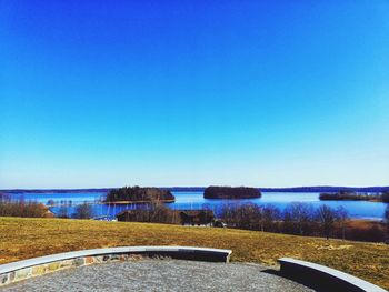 Scenic view of lake against clear blue sky