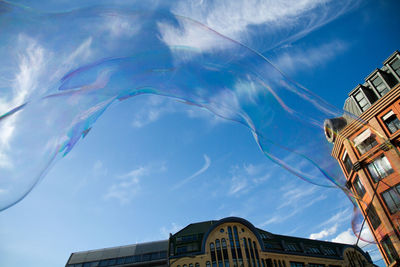 Low angle view of bubbles and buildings against sky