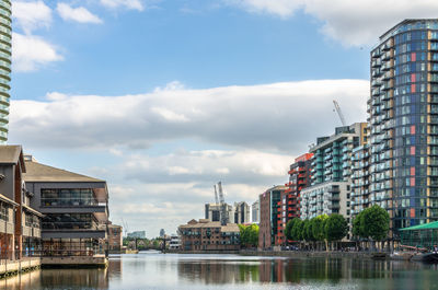 Buildings in city against cloudy sky