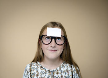 Portrait of woman wearing sunglasses against pink background