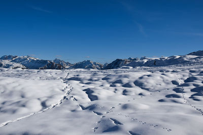 Scenic view of snow mountains against blue sky