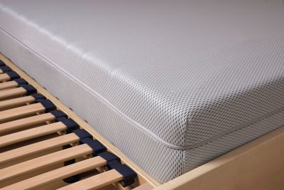 Close-up of cold foam mattress on wooden bed