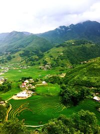 High angle view of green landscape against sky