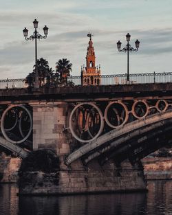 View of bridge over river against cloudy sky