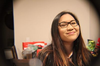 Smiling young woman wearing eyeglasses at home