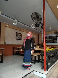 Full length of woman standing on tiled floor