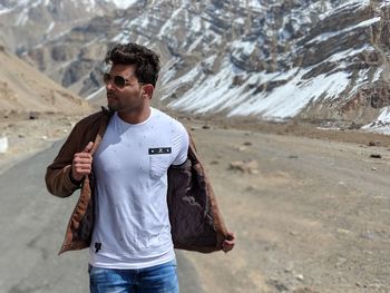 Young man wearing sunglasses standing on mountain