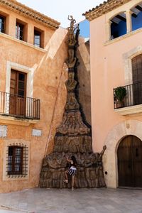 Rear view of girl standing by building in city