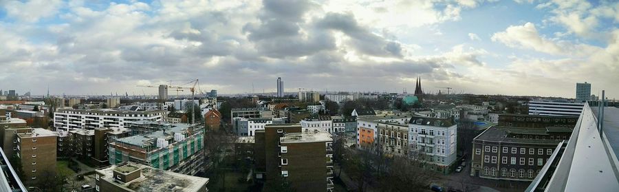 Cityscape against cloudy sky