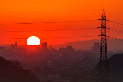 Silhouette electricity pylon against clear sky during sunset