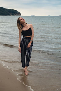 Rear view of woman standing at beach