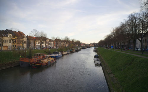 Canal amidst buildings in city against sky