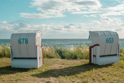 Two white beach chairs with blue numbers on them in germany on the island rügen
