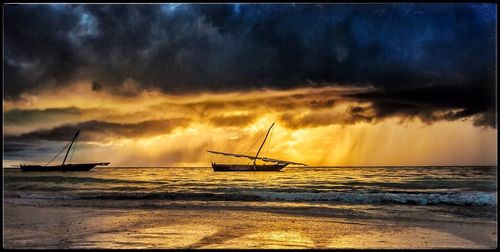 Boats in sea against cloudy sky